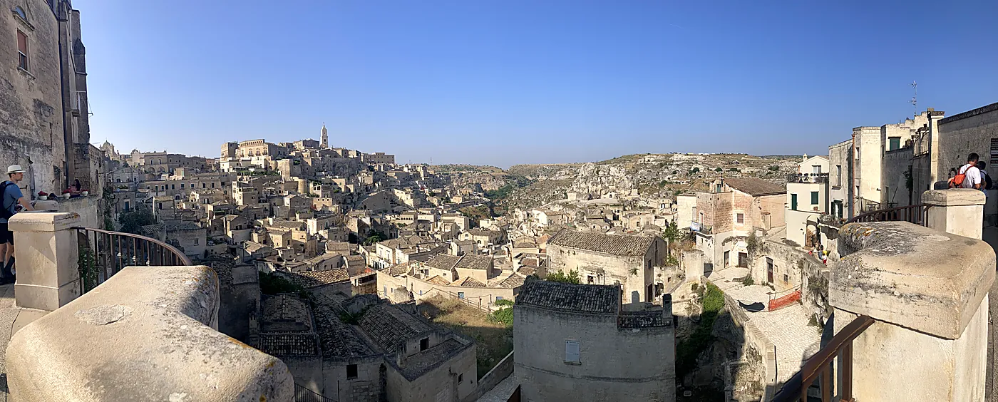 Veduta panoramica dei Sassi di Matera nel sole del pomeriggio, con il campanile del Duomo sul colle.