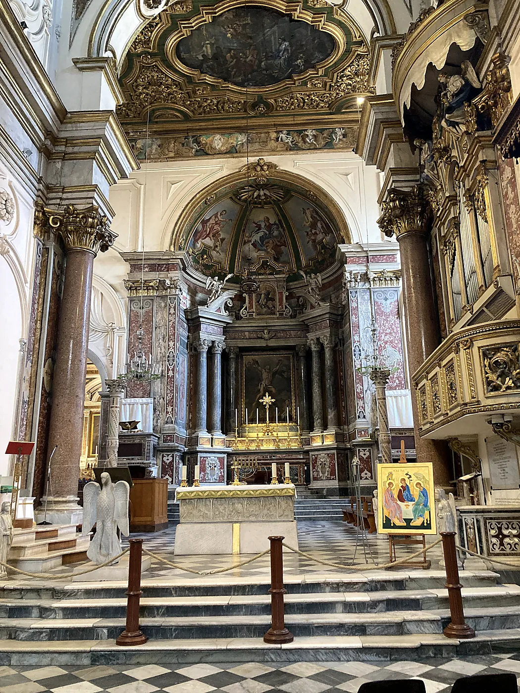 La navata e l'altare maggiore del Duomo di Amalfi, con le colonne di marmo rosso e i soffitti dorati.