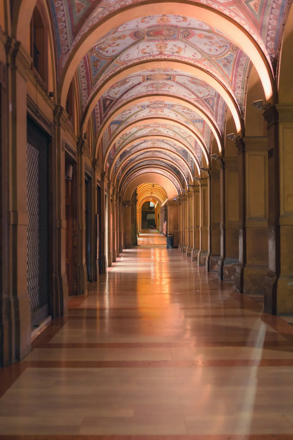 Un portico di Bologna con le volte affrescate e il pavimento lucido