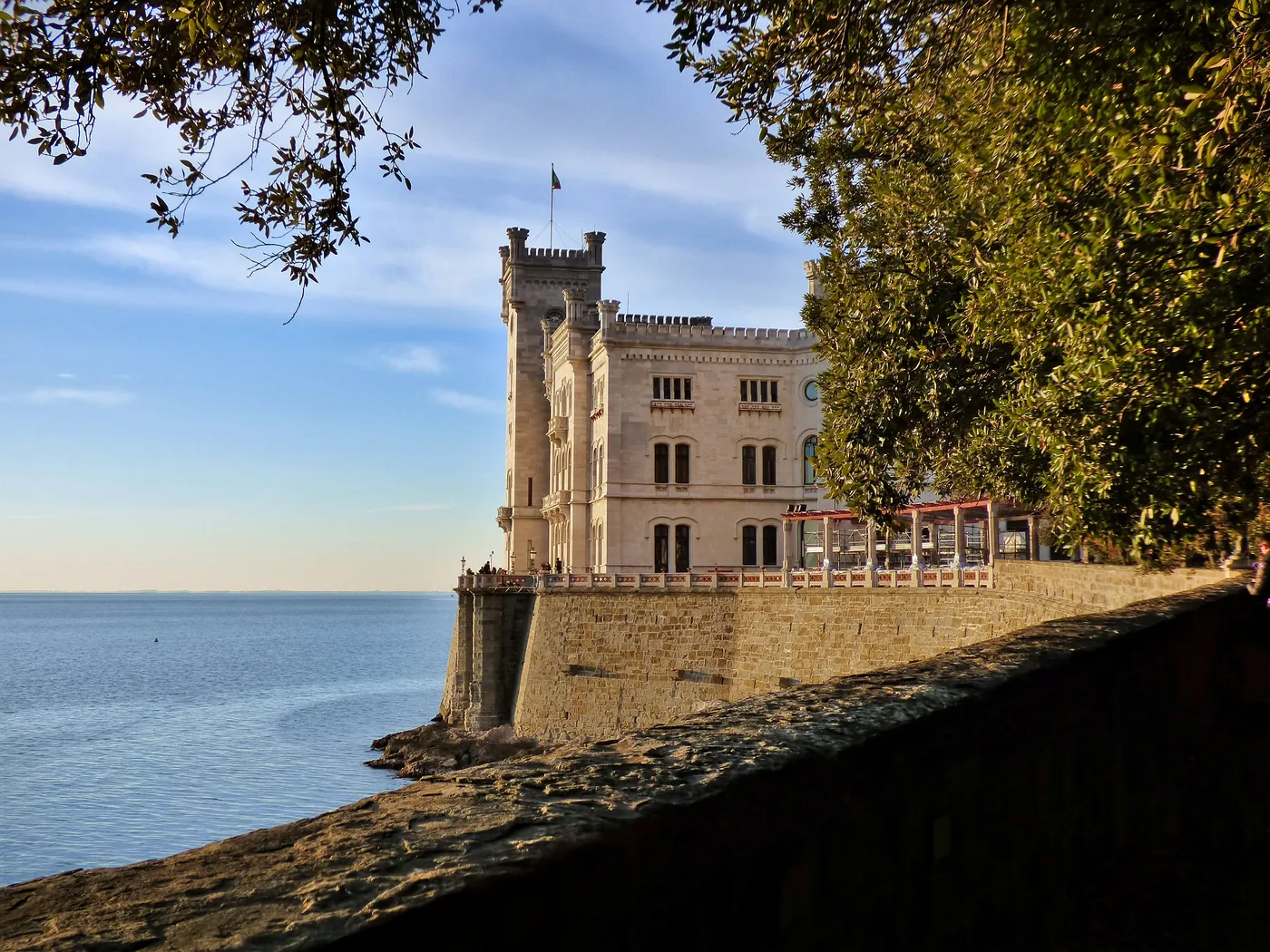 Il castello bianco di Miramare sul mare di Trieste, tra i rami di un leccio