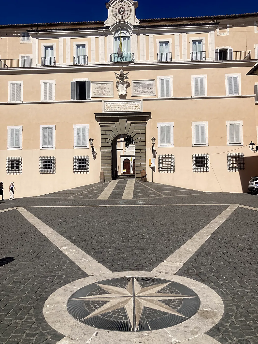 La facciata del Palazzo Apostolico di Castel Gandolfo su piazza della Libertà, con l'orologio e la rosa dei venti nel selciato.