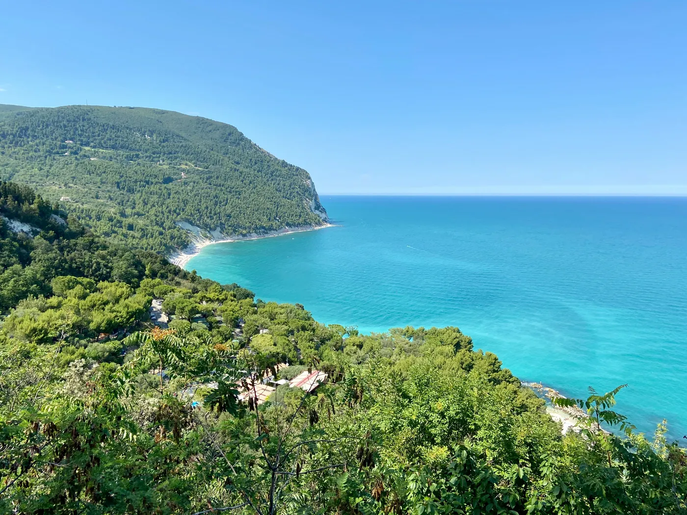 Il monte Conero verde che scende nel mare turchese dell'Adriatico