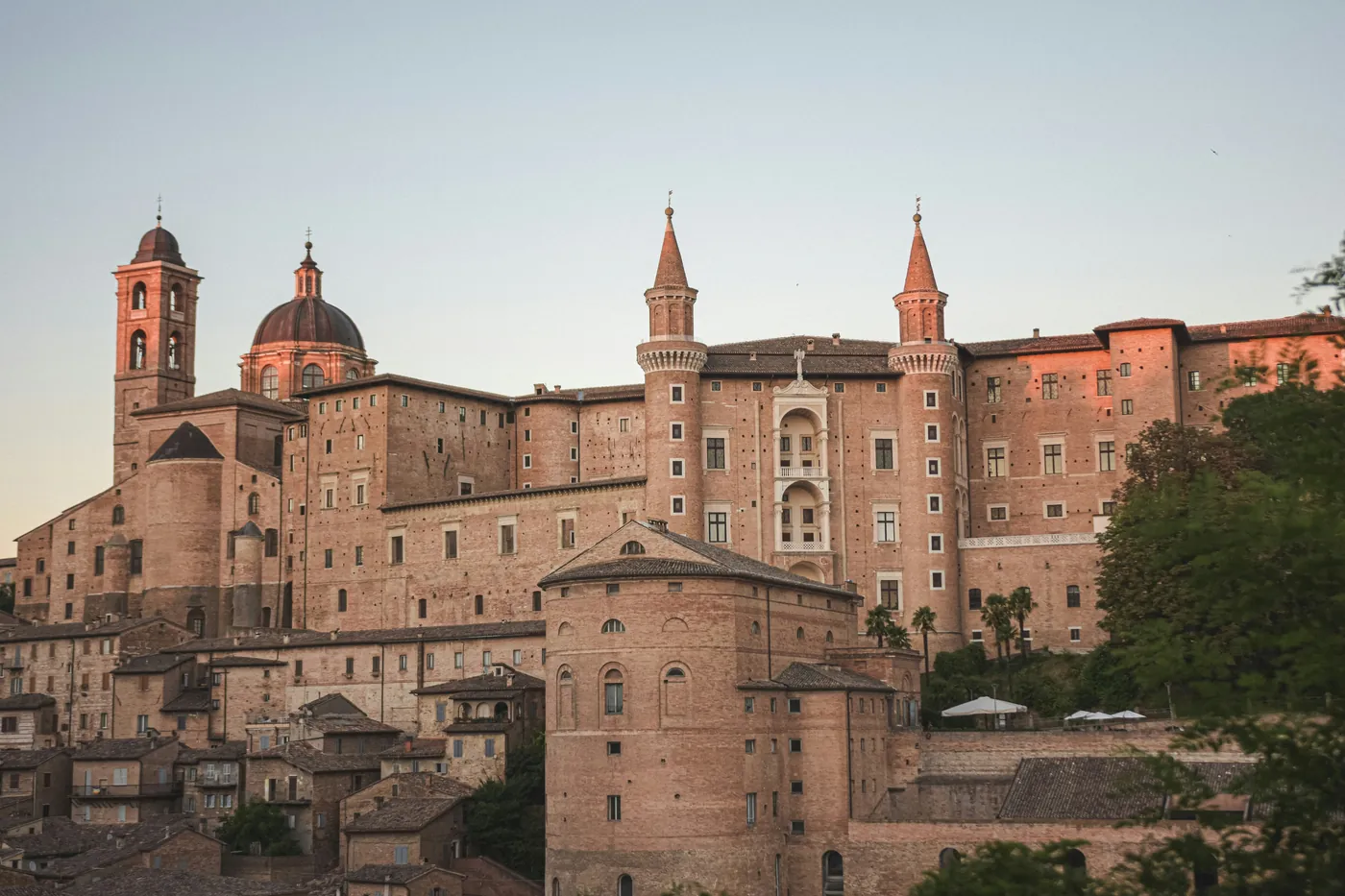 Il Palazzo Ducale di Urbino con i torricini e la cupola del Duomo nella luce del tramonto