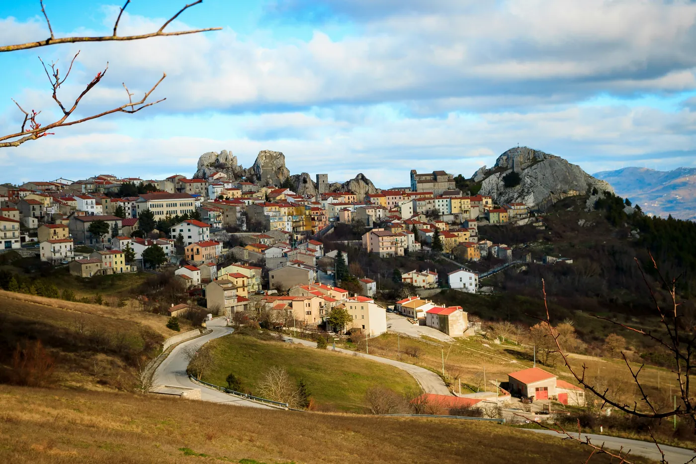 Un borgo di montagna del Molise con i tetti rossi ai piedi di grandi rocce