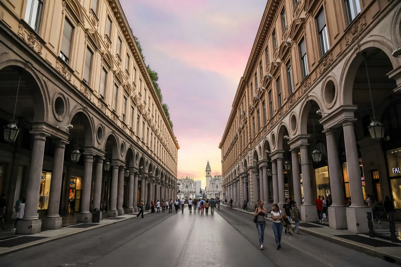 I portici di via Roma a Torino al tramonto, con le chiese di piazza San Carlo in fondo