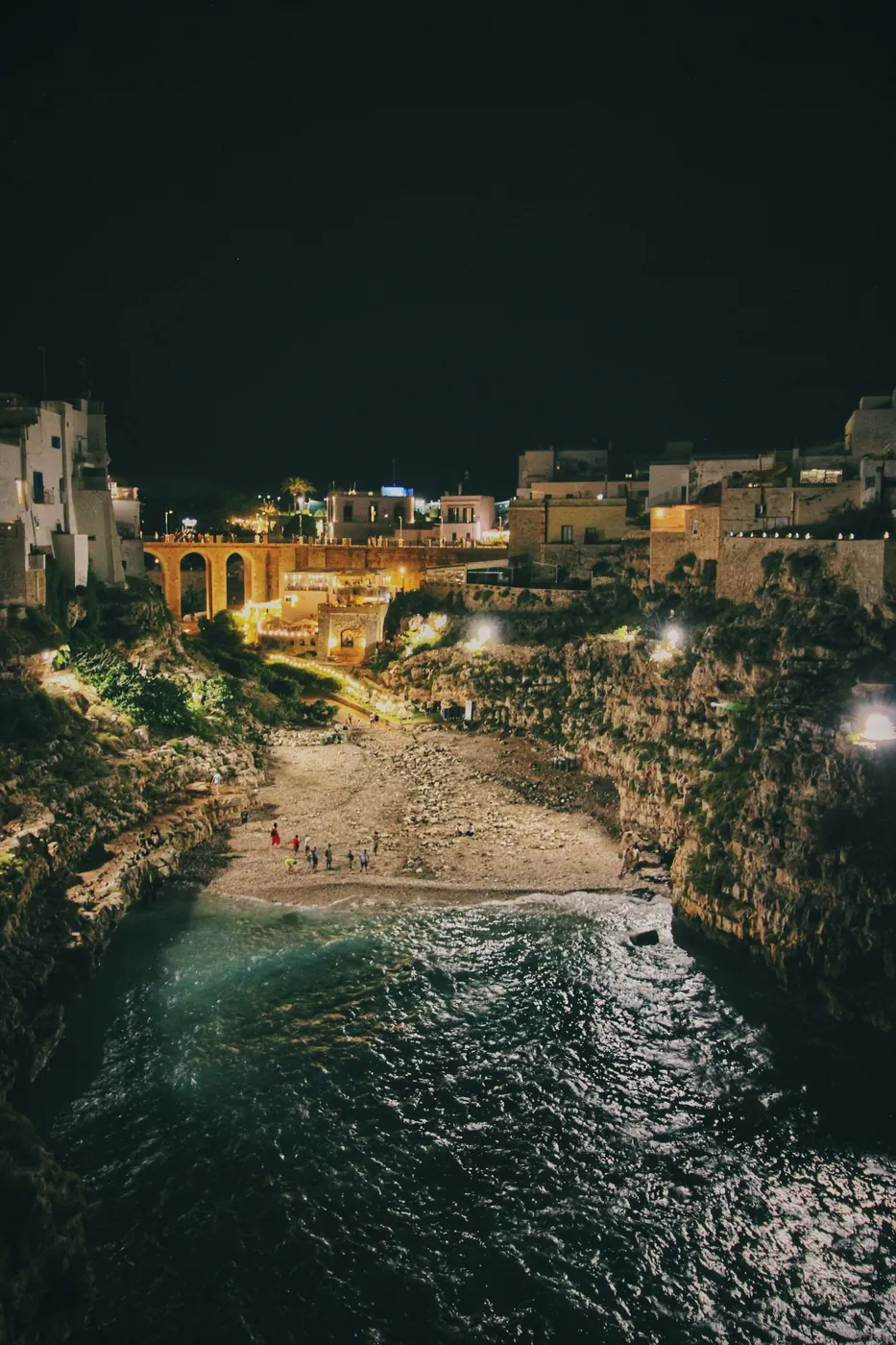 La cala di Lama Monachile a Polignano a Mare di notte, con il ponte e le case illuminate