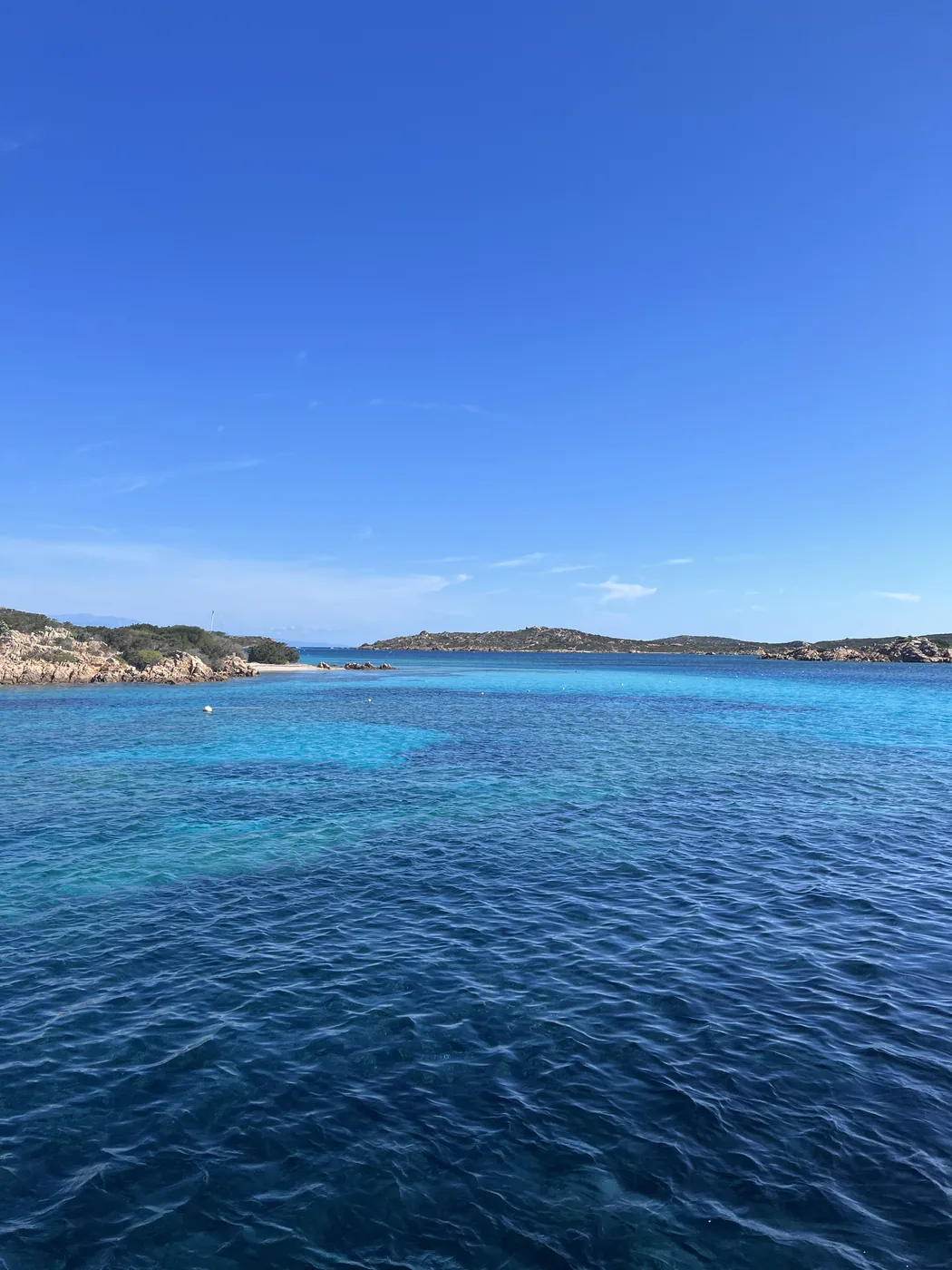 Il mare blu intenso della Sardegna sotto un cielo terso