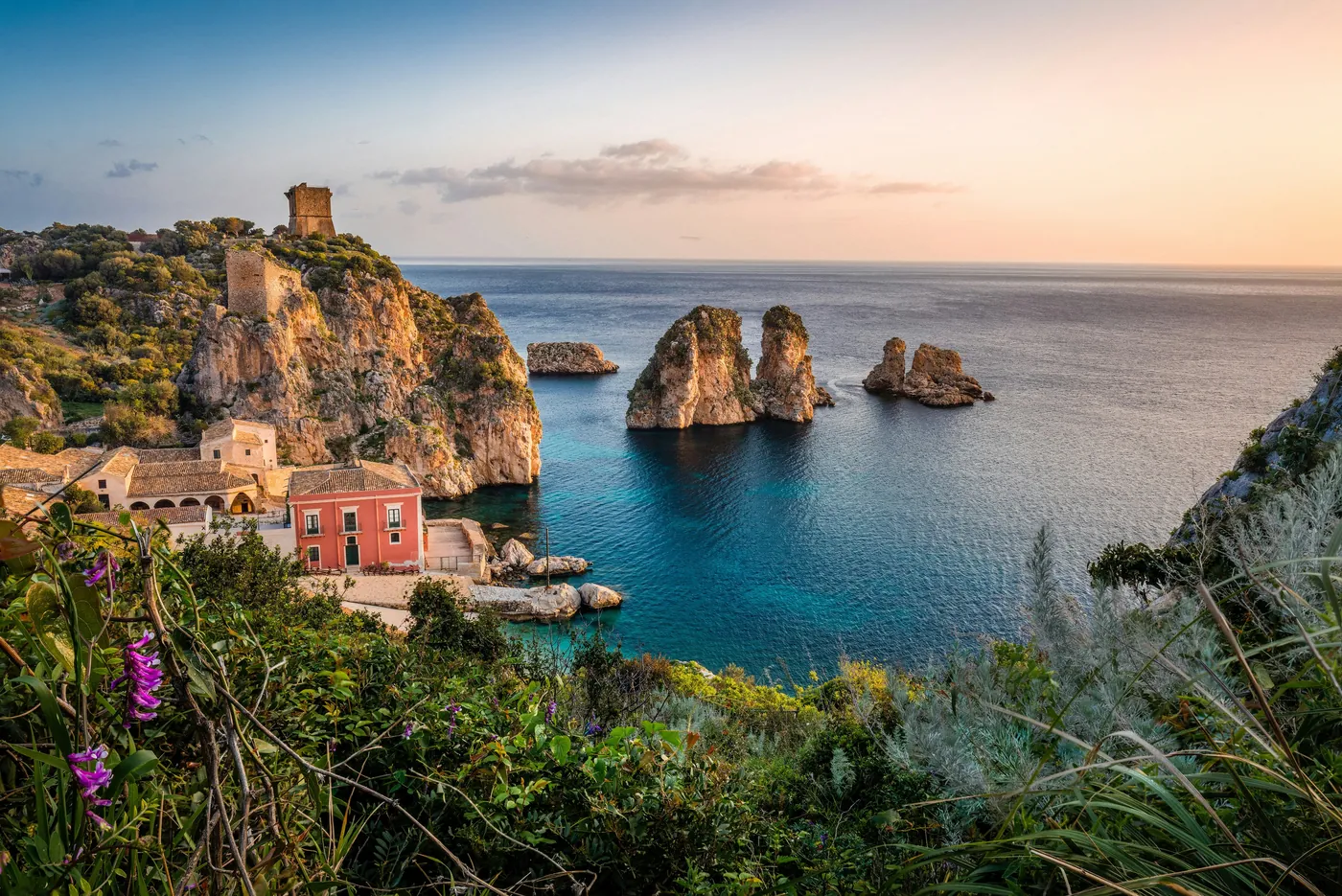 La tonnara di Scopello con i faraglioni e le torri sulla scogliera, nella luce dorata della sera