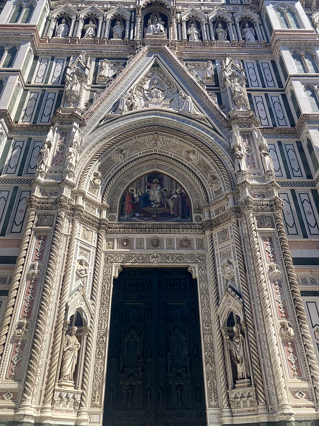 Il portale maggiore della cattedrale di Santa Maria del Fiore a Firenze, con il mosaico della lunetta e i marmi bianchi, verdi e rosa.