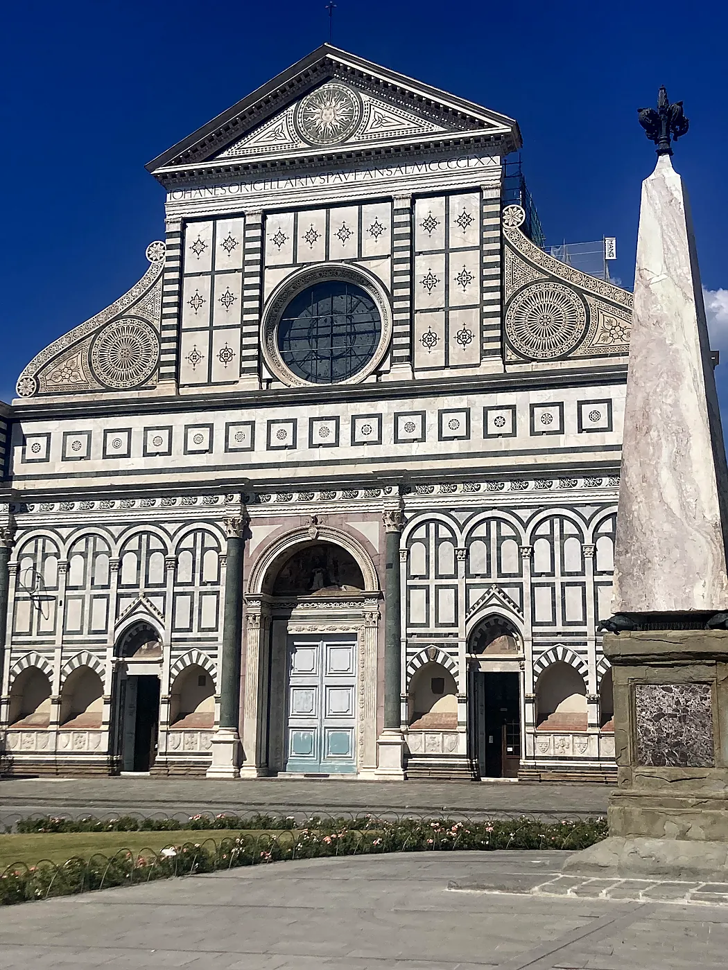 La facciata di marmo di Santa Maria Novella a Firenze, disegnata da Leon Battista Alberti, con l'obelisco della piazza in primo piano.