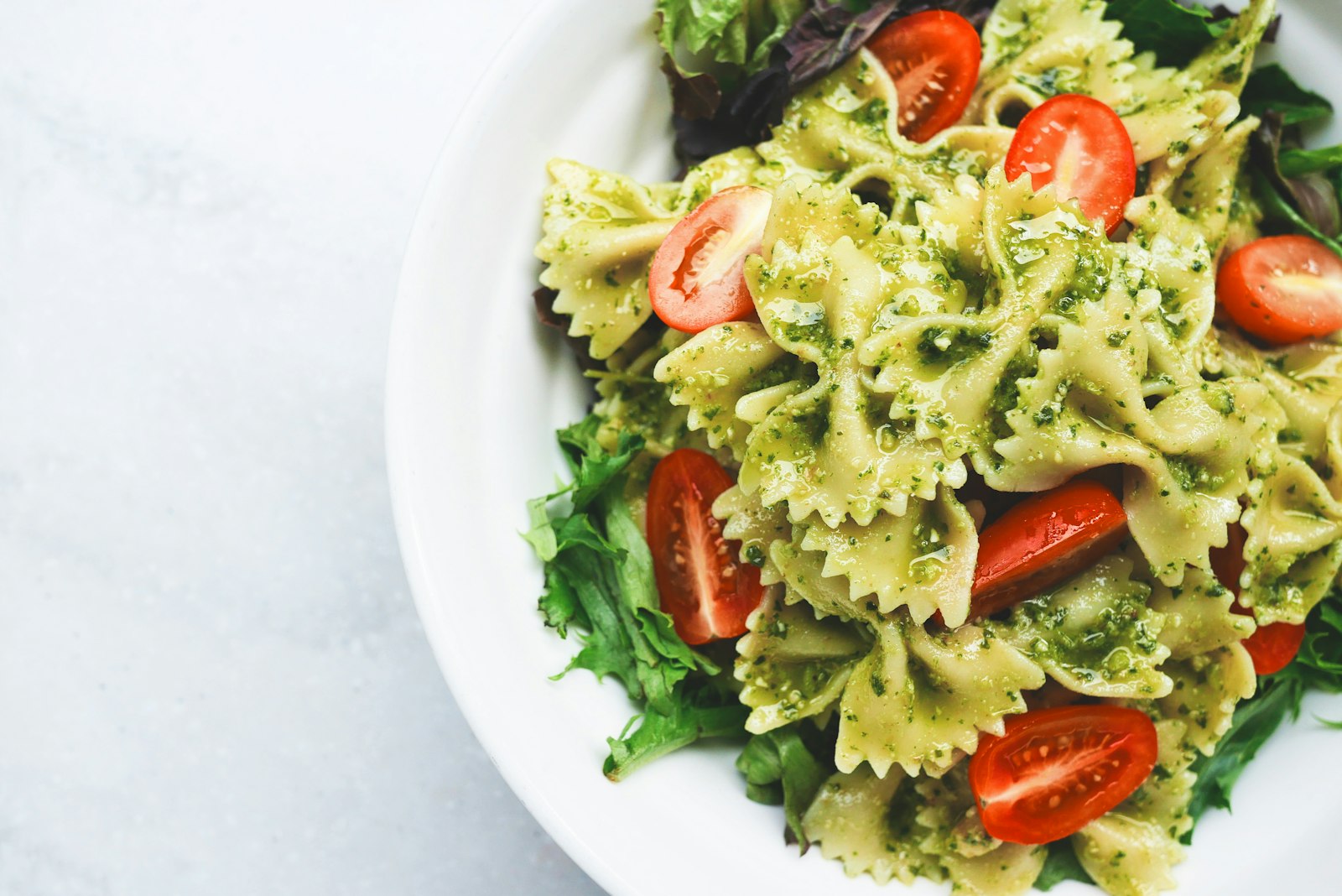 Piatto di pasta al pesto con pomodorini freschi