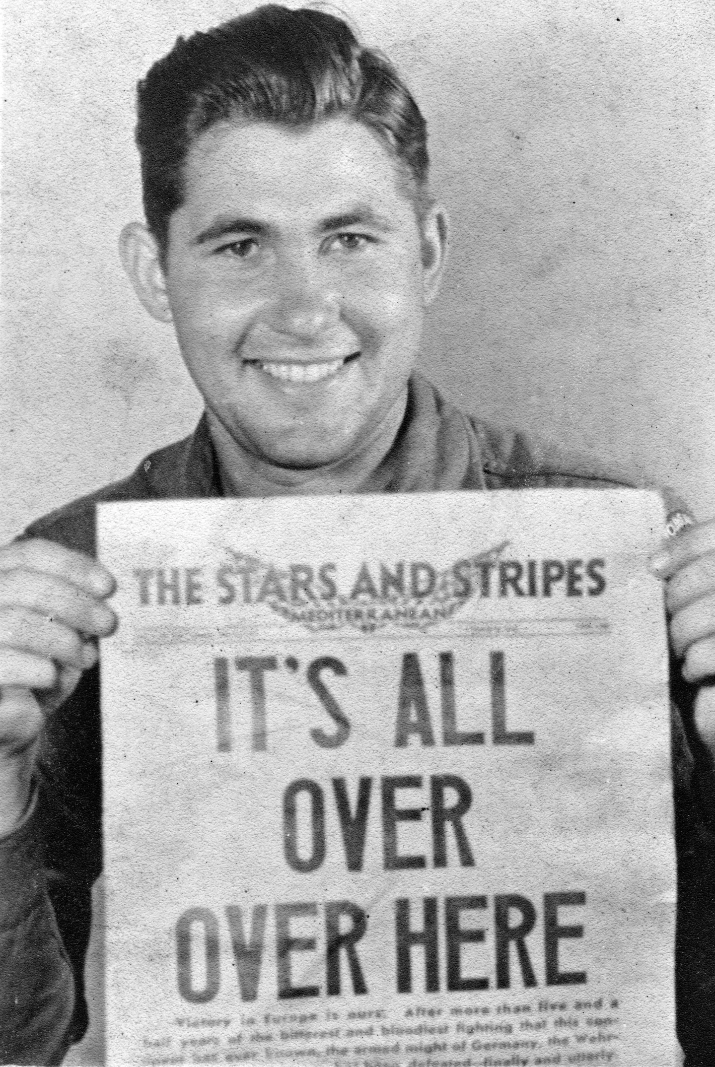 Un soldato americano sorride reggendo la prima pagina di Stars and Stripes che annuncia la fine della guerra