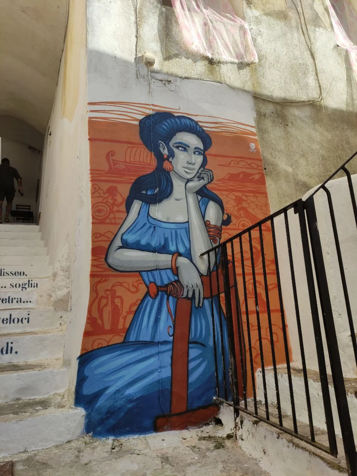 Il murale di Penelope con il viso appoggiato sul palmo della mano